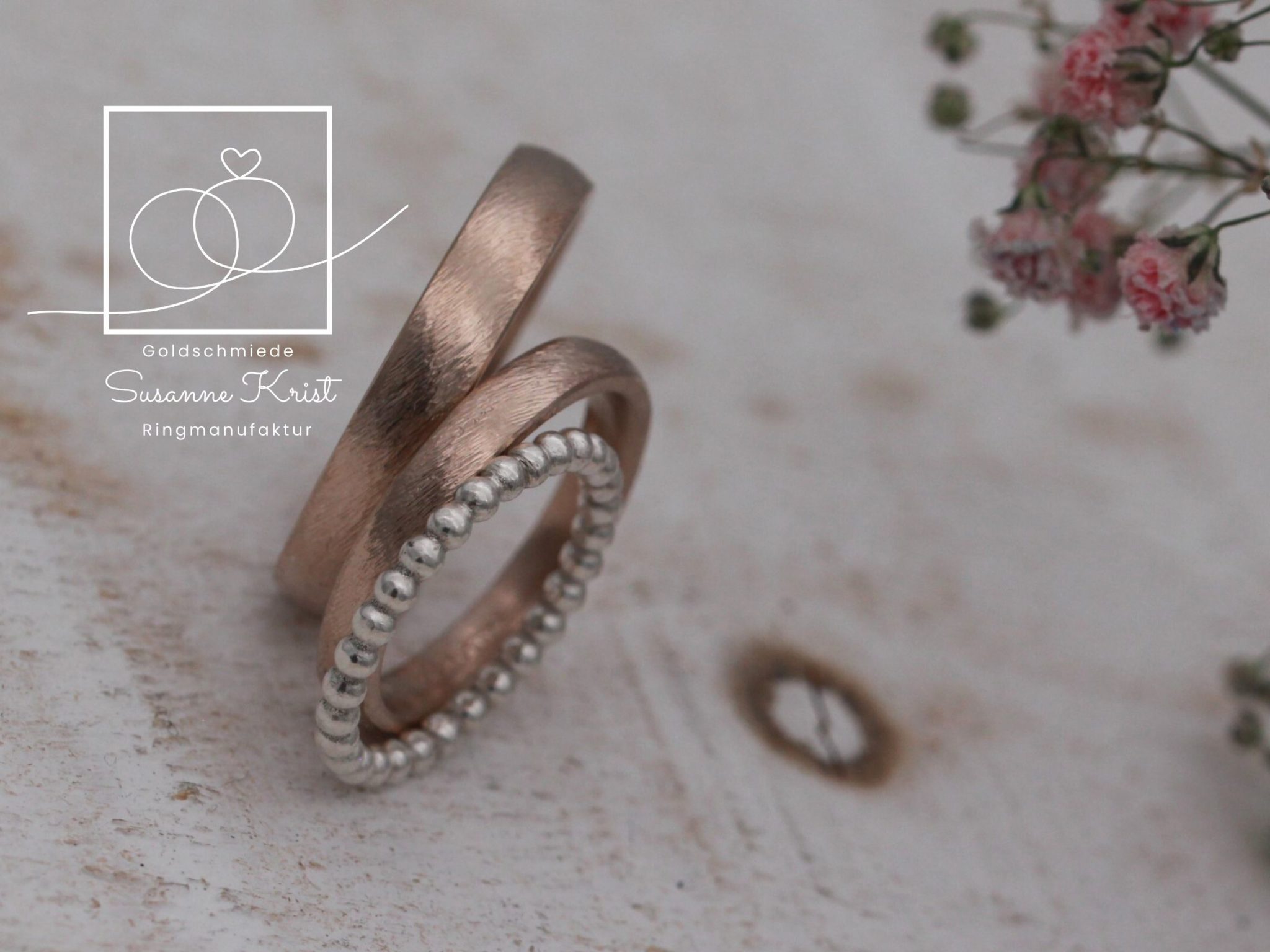 Auch sehr kombinationsfreudig: Schlichte Trauringe aus Haselnussgold mit weißem Kugeldring dazu.